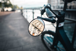 View of an old city building in Geneva through a mirror attached to a bicycle 