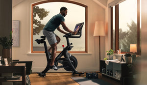 Man cycling on a Peloton bike in his home