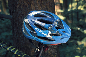 Beaten-up bicycle helmet resting on a bike saddle