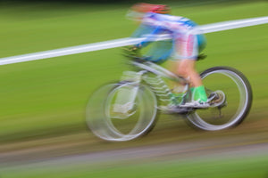 Blurred image of a cyclist speeding by on his bike