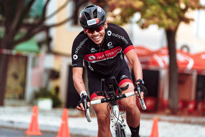 Man cycling in a road race and looking happy.