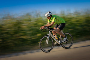 Man leaning on handlebars looking tired as he coasts downhill on his bike