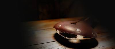 Brown bike saddle on a wooden backdrop