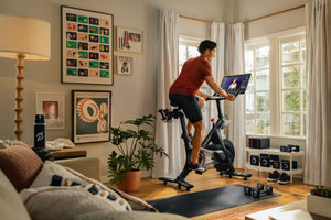 Man riding Peloton bike in his living room