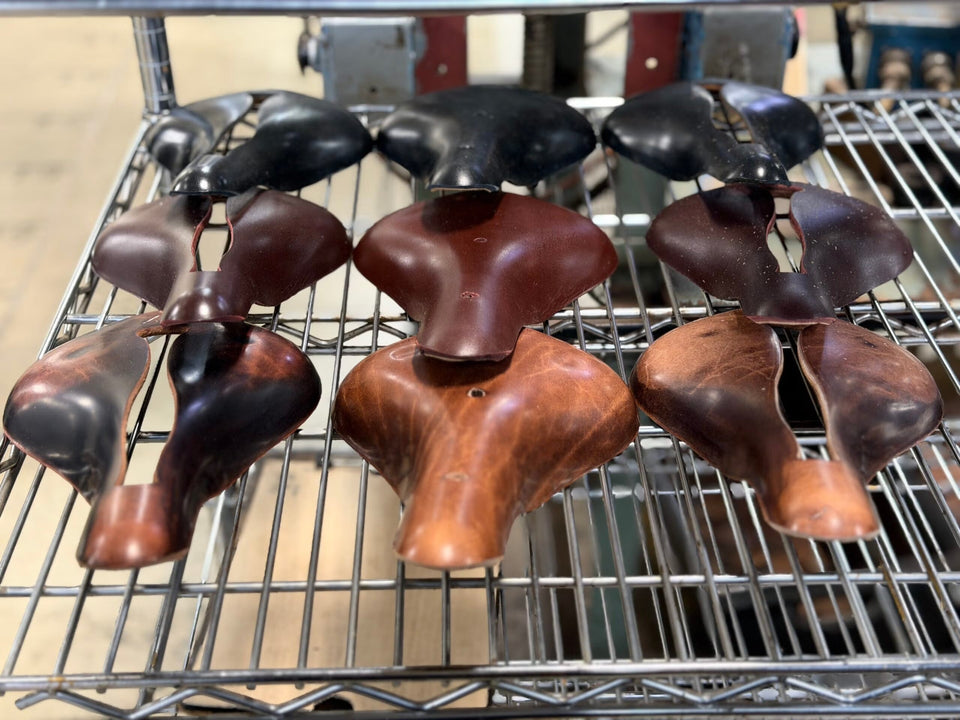 A shelf of Selle Anatomica leather saddle tops on a rack at Monarch McLaren in Elkhorn, WI