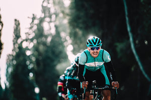 Cyclist in sunglasses leading a line of riders