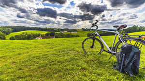 Road bike parked by a cycling backpack overlooking beautiful green rolling hills in Bavaria