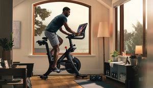 Man riding a Peloton bike in his home workout space