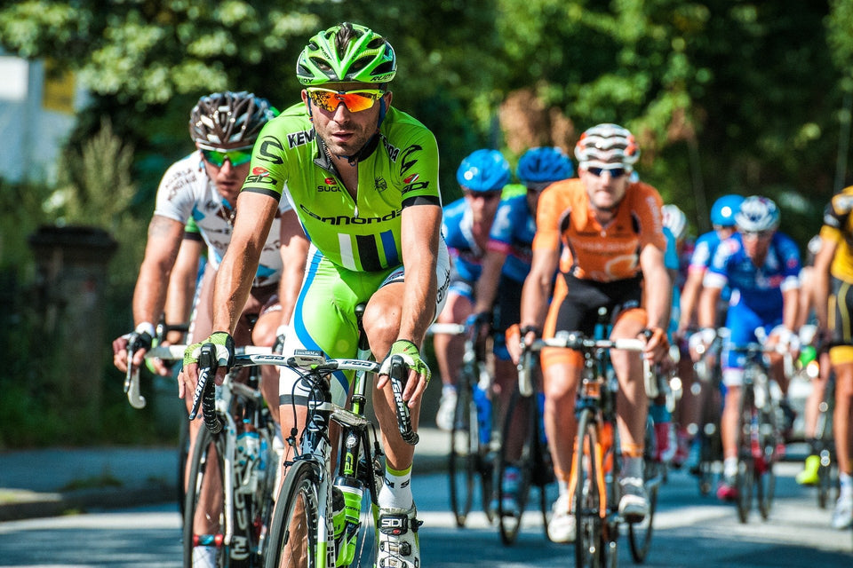 Group of cyclists riding together on the road on a sunny day
