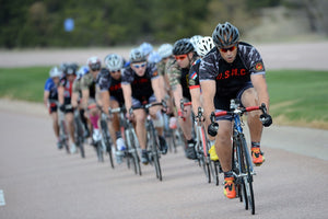 Cyclists racing in a line up the road