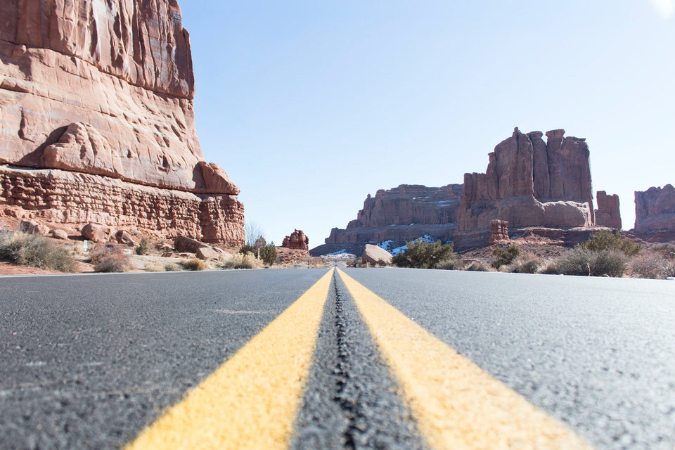 View along a crack in the road leading toward rock formations in Moab, Utah