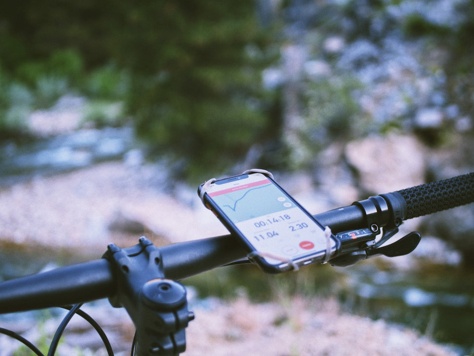 Smartphone attached to bicycle handlebars monitoring workout data