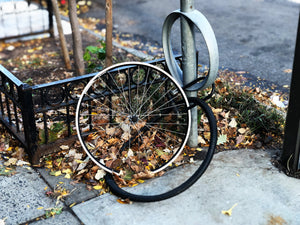 Bike wheel and tire left locked to a bike rack after the rest of the bike was stolen