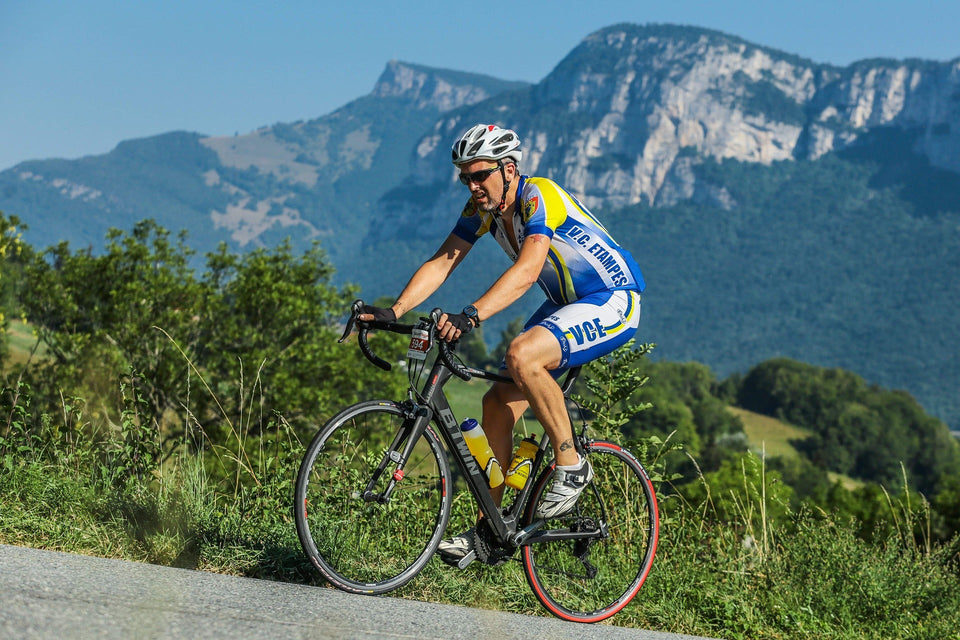 Man cycling up a hill with an pained expression