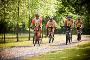 Group of happy mountain bikers riding on a park trail