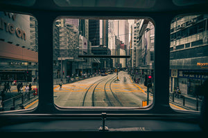 View from inside a train car looking out over tracks through a city intersection