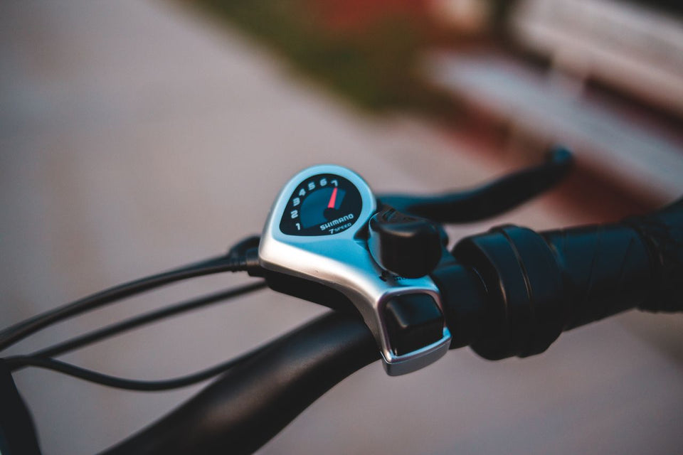 Close-up view of a modern electronic bicycle gear shifter on a handlebar.