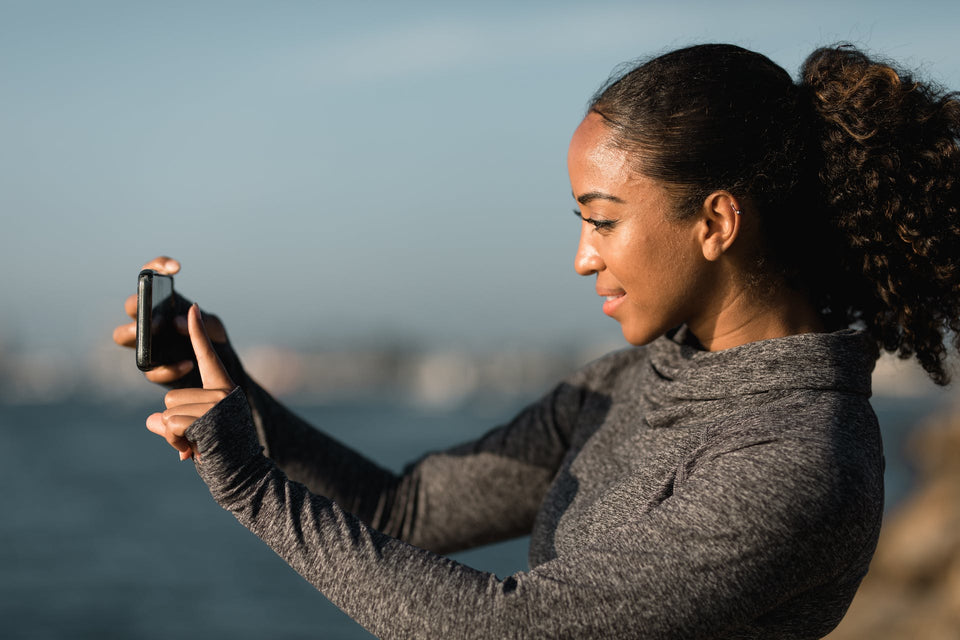 Side view of a woman taking pictures with her cell phone