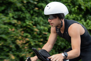 Man in a loose helmet riding a bike