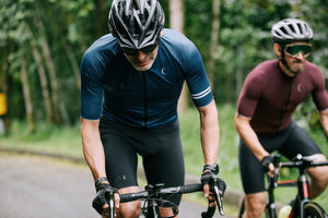 Cyclists riding on a road near a forest