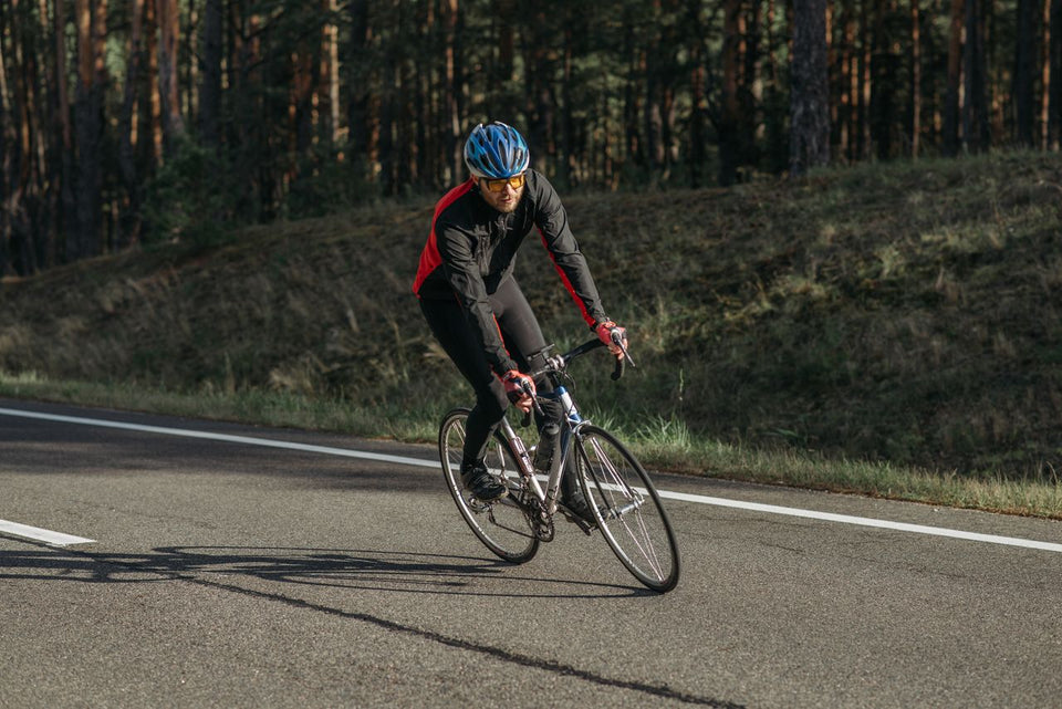 Serious road cyclist rounding a bend in the road on his bike