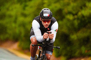 Front view of a cyclist leaning in and pedaling hard with a determined look on his face