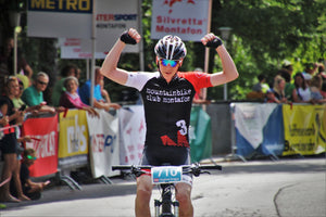 Cyclist with arms raised celebrating a win