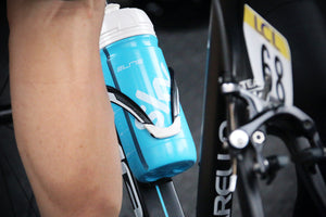 Close-up of a cyclist’s leg and water bottle in its holster on the bike