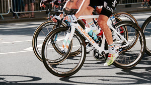 Lower body and bikes of several road cyclists in a race