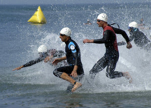 Men diving into open water in a triathlon swim