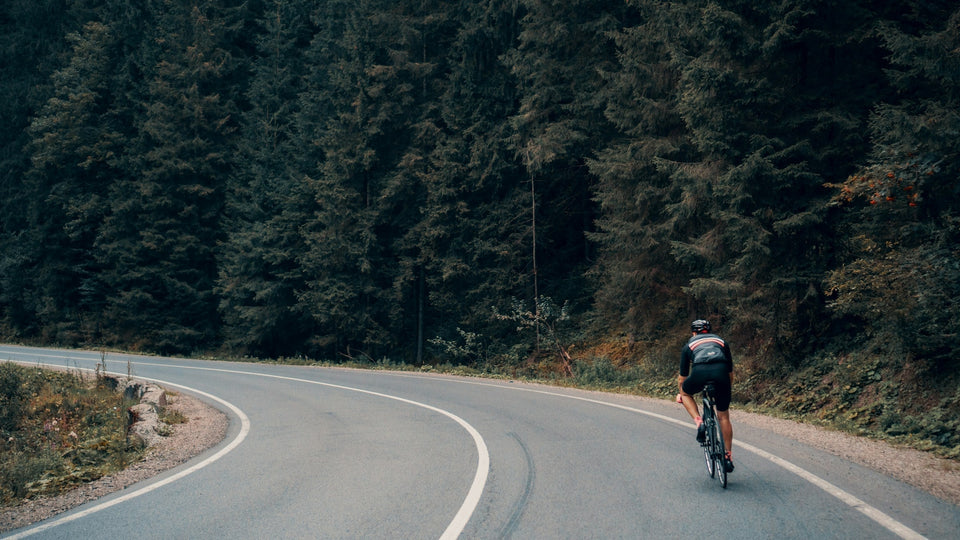 Man cycling down a curvy mountain road