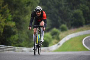 Front view of man pedaling his bike hard uphill