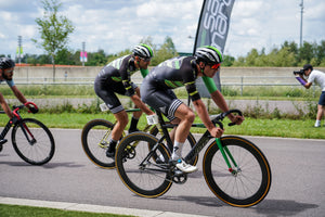Three men pedaling around the bend in the road during a cycling competition