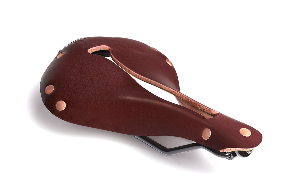 The X1 bicycle saddle by Selle Anatomica, in reddish brown oxblood  leather with copper colored rivets