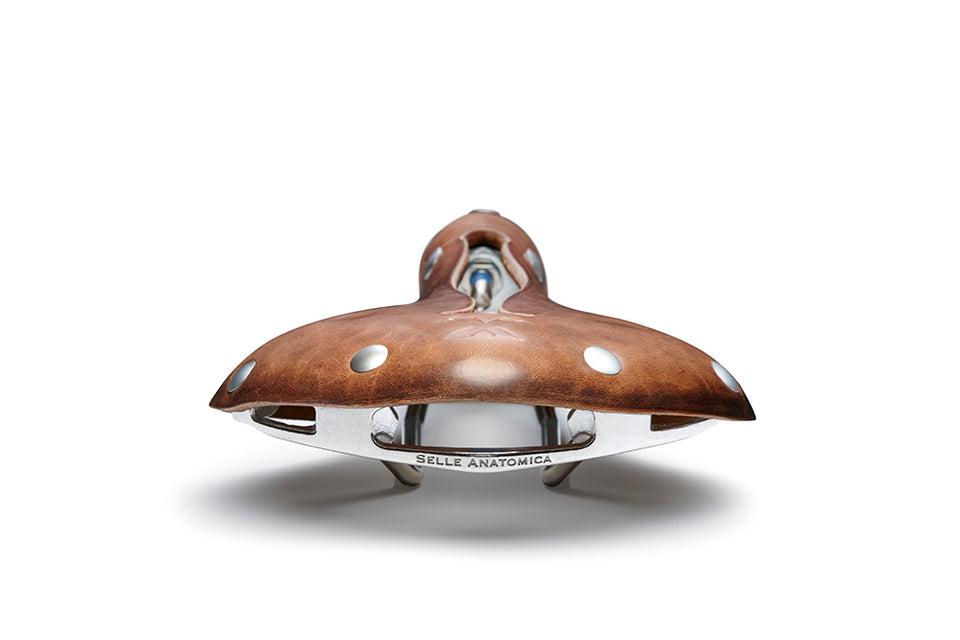 Back side of the X2 saddle in tool leather with silver accents, showing off the Selle Anatomica logo on the lightweight modular frame