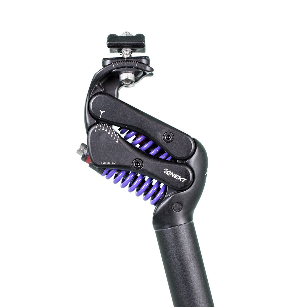A closeup of a black, adjustable seatpost with purple, shock absorbing springs and a control knob