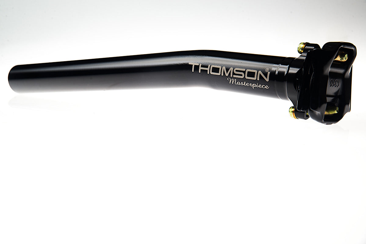 A black, slightly angled seatpost with a large Thomson Masterpiece logo
