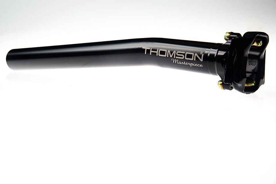 A black, slightly angled seatpost with a large Thomson Masterpiece logo